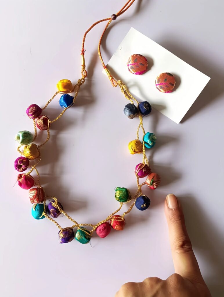 Imahe shows a Handmade necklace set with crochet beads and handpainted cloth pendant for a vibrant ethnic charm.