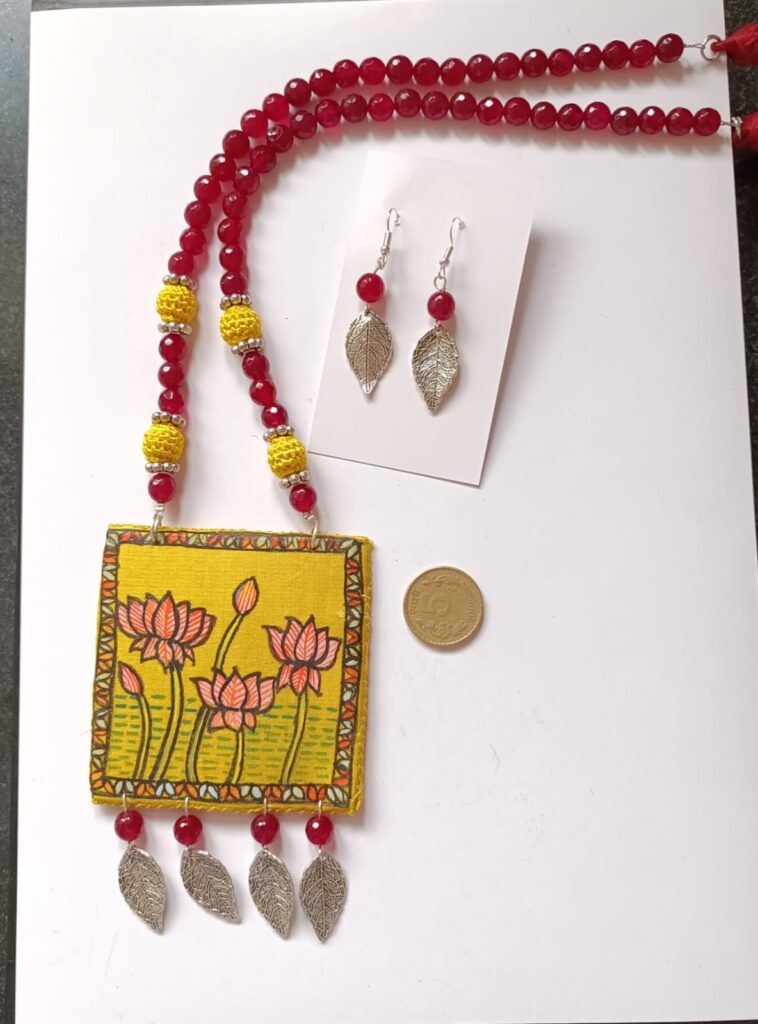 Image shows a Handmade full set of metal beads and handpainted cloth pendant