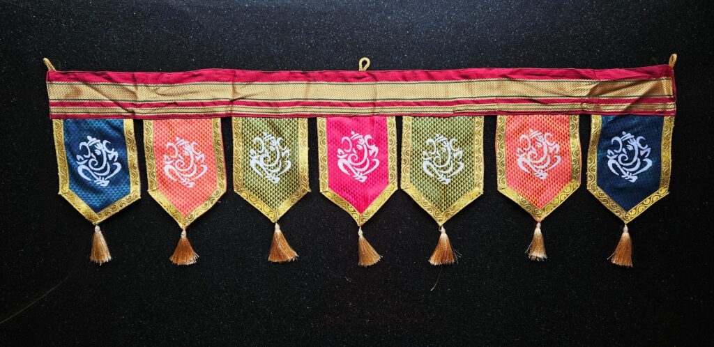 Image shows a TRADITIONAL TORAN MULTIPLE RECTANGULAR AND POINTED FABRIC ADORNED WITH STYLIZED GANESHA SYMBOL