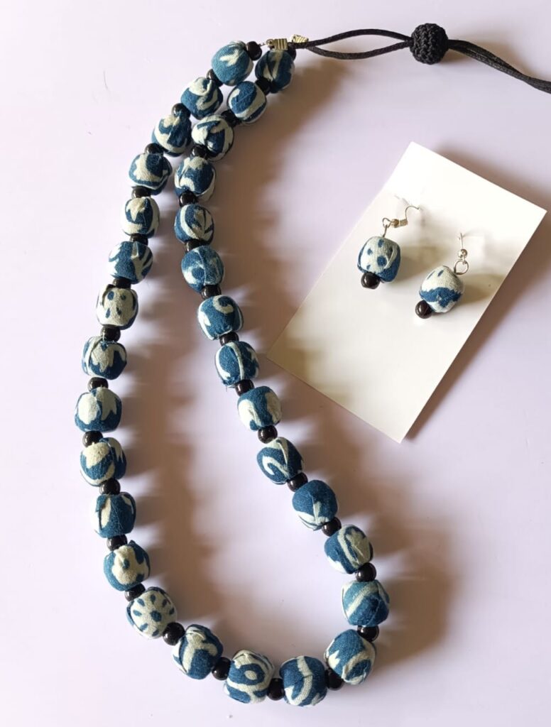 Image shows a handmade neclace set with cloth beads